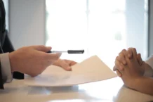 Best Critical Thinking Interview Questions to Ask (2026) crop businessman giving contract to woman to sign