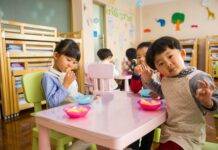 three toddler eating on white table