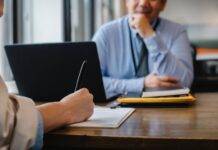 woman filling job application form in office with boss